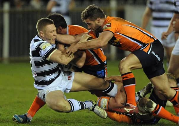 Hull FC's Chris Green brought to ground by Castleford's players.