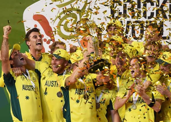 Australian captain Michael Clarke holds the trophy with his teammates as they celebrate their seven wicket win over New Zealand in the Cricket World Cup final in Melbourne (AP Photo/Andy Brownbill)