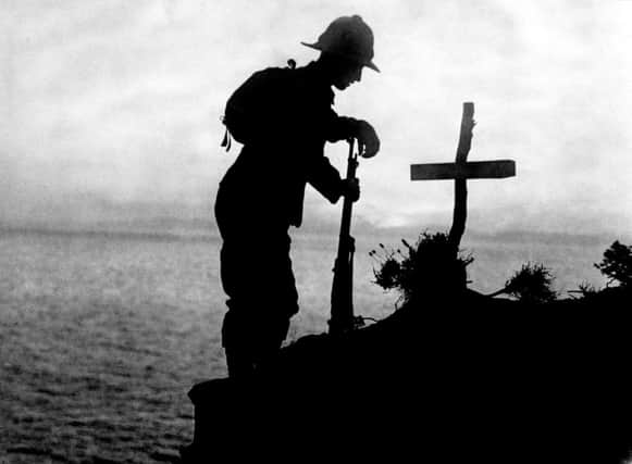 A British soldier pays his respects at the grave of a colleague near Cape Helles, where the Gallipoli landings took place. (PA Archive/Press Association Images).