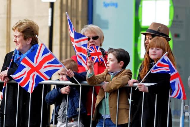 Members of the public wave their flags as they wait for the Queen outside Sheffield Cathedral on Maundy Thursday. Picture: Andrew Roe