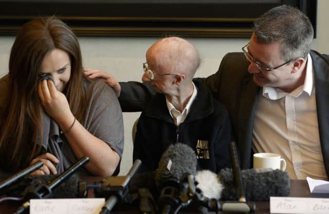 Katie Cutler, who rasied over £300,000 for Alan Barnes (middle), breaks down in tears as Mr Barnes and his brother-in-law Paul Lore comfort her, after hearing the news that Richard Gatiss was sentenced to 4 years after admitting trying to mug the visually-impaired pensioner