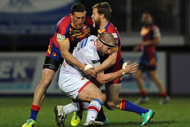 DOWN: Wakefield's Nick Scruton is well wrapped up by the Catalans defence. Picture> RLPHOTOS.COM