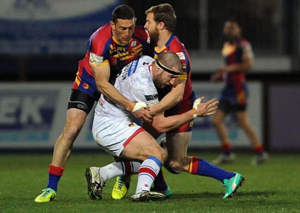 DOWN: Wakefield's Nick Scruton is well wrapped up by the Catalans defence. Picture> RLPHOTOS.COM