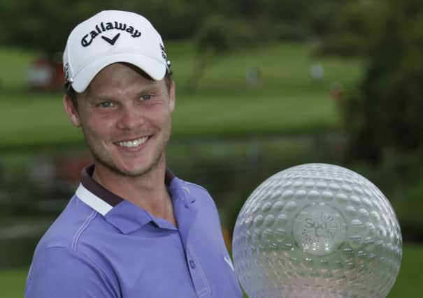 Danny Willett of England holds the trophy after winning the Nedbank Golf Challenge at the Gary Player Country Club in Sun City. (AP Photo/Themba Hadebe)