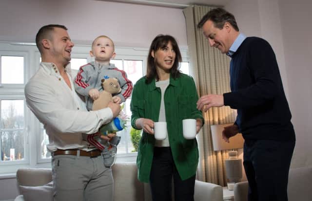 Prime minister David Cameron and his wife Samantha meet first time home buyer Robert Arron (left) and his son Finlay.