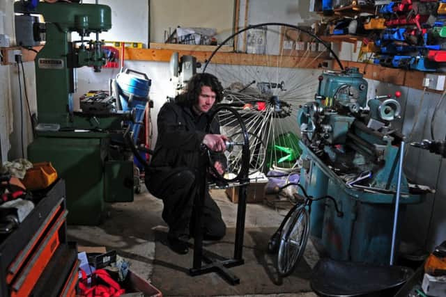 Christian Richards from Aldbrough, East Yorkshire, in his workshop where he handmakes penny farthings. He has now made one for son Austin, 2, with a 20inch wheel, a prototype for the world's smallest penny farthing.