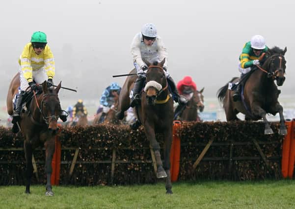 Eventual winner Cape Tribulation ridden by Denis O'Regan (centre) races Catch Me ridden by Tony McCoy (right) and Cantlow ridden by Dominic Elsworth (left)