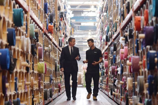 Prime Minister David Cameron meets  apprentice Cory Hurst (right) during a visit to Camira Fabrics in Huddersfield, where they make textiles for trains and buses.