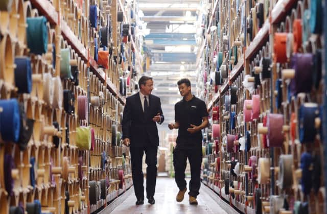 Prime Minister David Cameron meets  apprentice Cory Hurst (right) during a visit to Camira Fabrics in Huddersfield, where they make textiles for trains and buses.