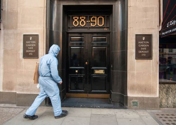 File photo dated 07/04/15 of a police forensics officer entering the Hatton Garden Safe Deposit company in London, as Scotland Yard confirmed it was investigating why the force did not respond to an intruder alarm which had been activated last Friday at Hatton Garden Safe Deposit Ltd which was raided over the Easter weekend. PRESS ASSOCIATION Photo. Issue date: Friday April 10, 2015. See PA story POLICE HattonGarden. Photo credit should read: Dominic Lipinski/PA Wire