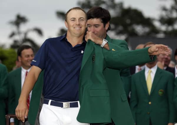 Bubba Watson, right, helps Jordan Spieth put on his green jacket after winning the Masters. Picture: AP/David J. Phillip.