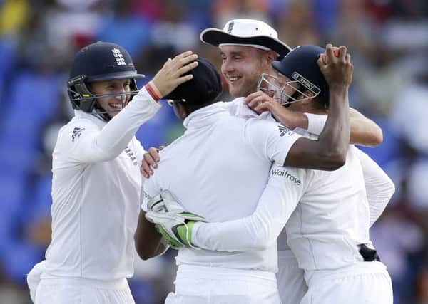 England's Joe Root, left, Stuart Broad, second from right and Jos Buttler embrace teammate Chris Jordan, back to the camera, after he caught West Indies' Kraigg Brathwaite.