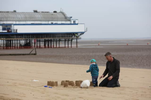 A father and son making sand castles on Cleethorpes beach on an overcast day in Lincolnshire.  Picture: Ross Parry Agency