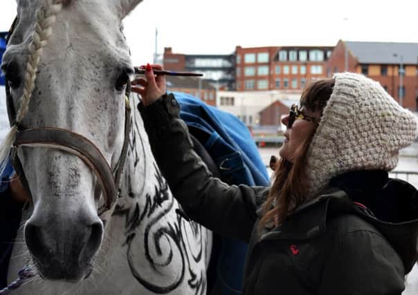 Fashion designer Lara Jensen paints an Andalusian stallion to promote Ladies Day at Beverley Racecourse.
