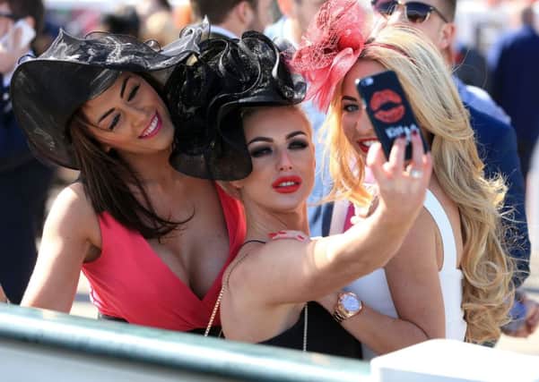 Rracegoers take a selfie during Grand National Day at Aintree Racecourse, Liverpool.