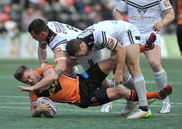 CRUNCH TACKLE: The charge of Castleford Tigers Grant Millington comes to an end as he is surrounded by the Widnes Vikings defence yesterday in Super League. Inset, Tigers James Clare. Picture: Ste Jones.