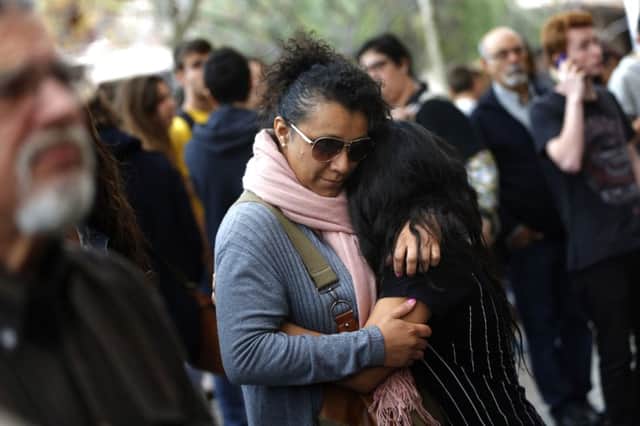 A woman comforts a young girl outside the school in Barcelona