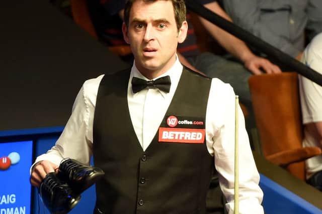 Ronnie O'Sullivan talks with referee Brendan Moore about his shoes his after he played in his socks against Craig Steadman, during the Betfred World Championships at the Crucible Theatre, Sheffield.