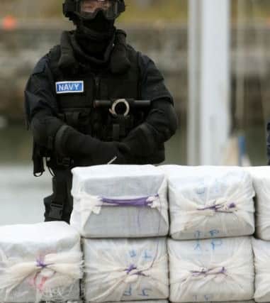 A member of the navy stands behind what is believed to be around 80 million euro (£62.5 million) worth of cocaine which was taken from onboard the yacht Makayabella