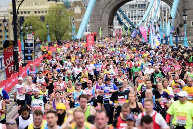 A marathon runners make their way over Tower Bridge during the 2015 Virgin Money London Marathon.