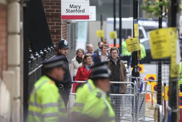 Wellwishers wait and celebrate together outside the Lindo Wing at St Mary's Hospital