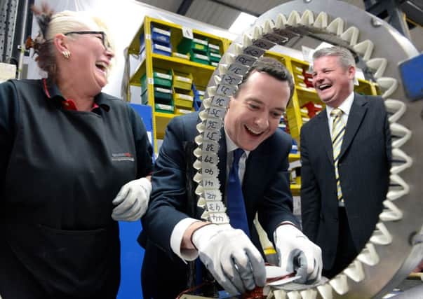 George Osborne tries his hand installing coils in part of a generator at Winder Power, Pudsey, with Supervisor Jane Paley and watched by Conservative Candiate Stuart Andrew.  5 May 2015.  Picture Bruce Rollinson