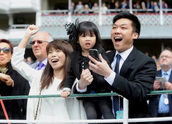 Lydia Luu aged 3 from Leeds, is pictured with her Mum Jun Cai and her dad Steve Luu cheering on a winner in the first race of the Dante Festival at York. (Simon Hulme)