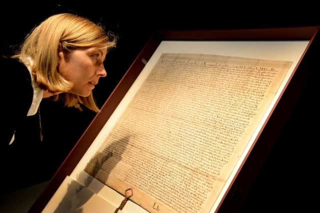 Carline de Stefani, conservator at London Metropolitan Archive, positions a 13th century copy of the Magna Carta during its installation at Heritage Gallery, in the City of London last year.  Pic: Andrew Matthews/PA Wire