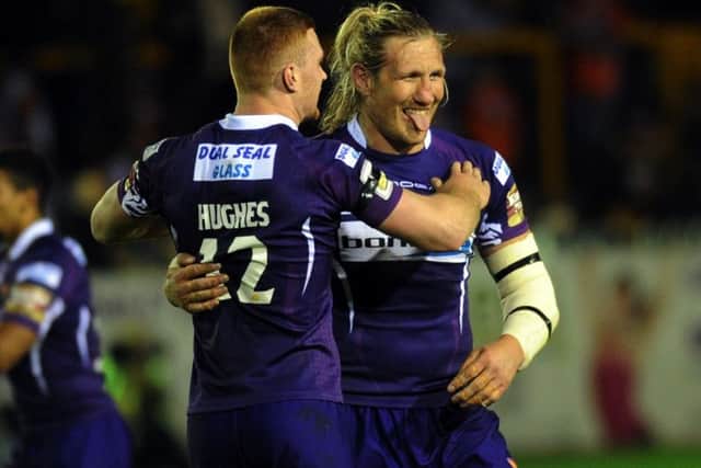 Huddersfield's Eorl Crabtree celebrates with Jack Hughes after his late try was awarded by the video referee.