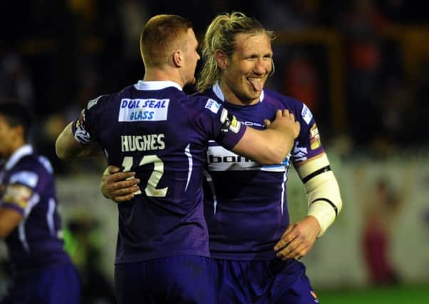 Huddersfield's Eorl Crabtree celebrates with Jack Hughes after his late try was awarded by the video referee.