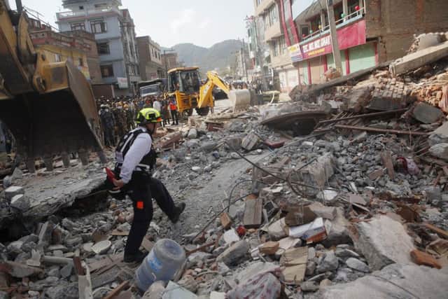 A rescue worker from USAID inspects the site of a building that collapsed in an earthquake in Kathmandu, Nepal, earlier this month. (AP Photo/Niranjan Shrestha)