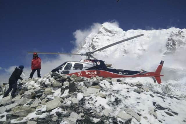 In this photo provided by Azim Afif, a helicopter prepares to rescue people from camp 1 and 2 at Everest Base Camp, Nepal after a large avalanche triggered by Nepal's massive earthquake slammed into a section of the Mount Everest mountaineering base camp, killing a number of people and left others unaccounted for. (Azim Afif via AP)