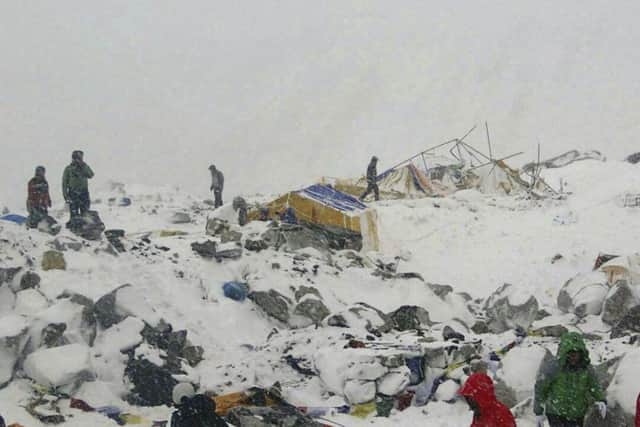 In this photo provided by Azim Afif people approach the scene after an avalanche triggered by a massive earthquake swept across Everest Base Camp, Nepal on Saturday, April 25, 2015. (Azim Afif via AP)