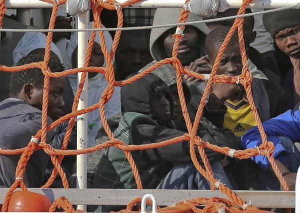 Migrants wait to disembark from the Italian Coast Guard