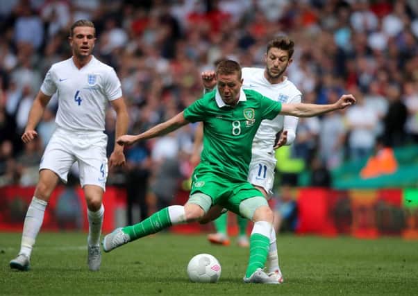 Republic of Ireland's James McCarthy (centre) battles with England's Adam Lallana at The Aviva Stadium, Dubli. Picture: Niall Carson/PA.