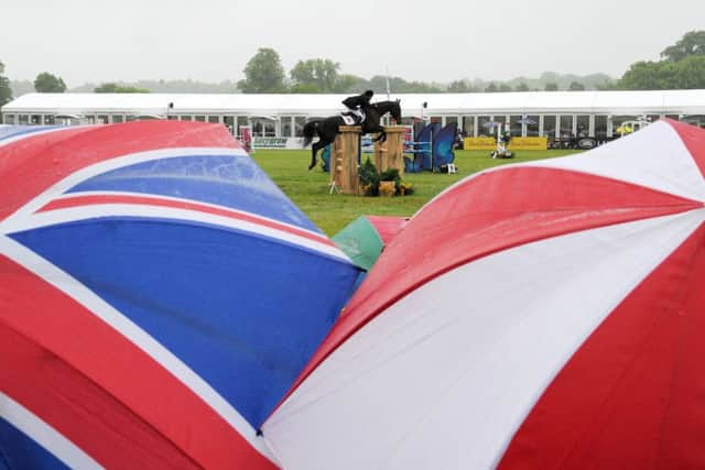 Fans watch the action from beneath their umbrellas at Bramham International Horse Trials. Picture: Anna Gowthorpe
