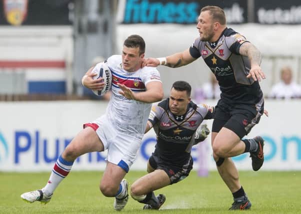 Wakefield's Joe Arundel is tackled by Salford's Mason Caton-Brown & Josh Griffin.