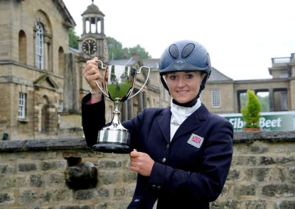 Holly Woodhead celebrates with the trophy after riding Dhi Lupison to victory.