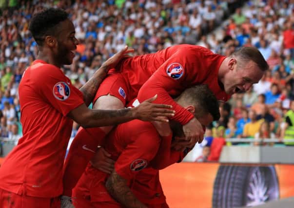 England's Jack Wilshire (centre) celebrates with team mate Raheem Sterling (left) and Wayne Rooney (top) after scoring his sides second goal in Slovenia.