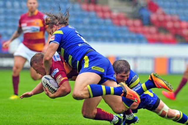 Huddersfield's  Luke Robinson takes a big hit from Wolves' Ashton Sims and Ben Harrison.