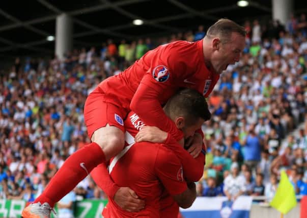 Wayne Rooney (top) celebrates with his England team-mates after their side's second goal against Slovenia on Sunday. Picture: Mike Egerton/P.