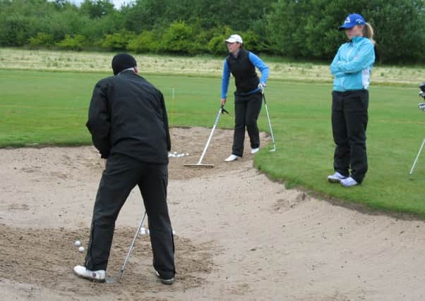 Coach Steve Robinson passes on some bunker expertise to Yorkshire Ladies Northern Counties Match Week team members Holly Morgan and Charlotte Austwick.