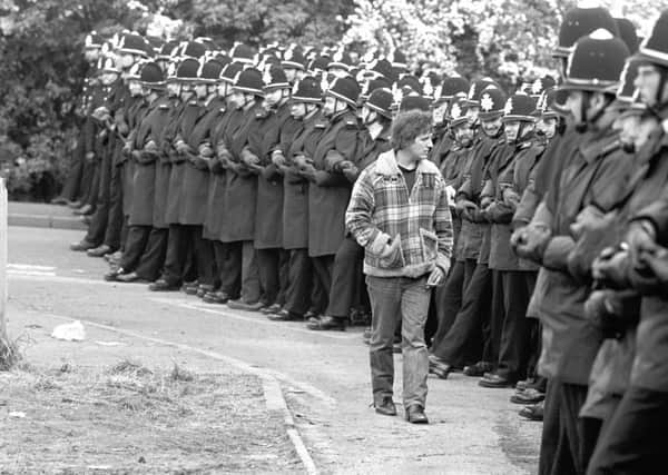 A member of the picket inspecting the police outside the Orgreave Coking plant near Rotherham during the miners' dispute, as the miners' strike started in Yorkshire in early March 1984