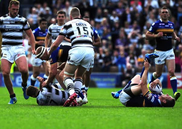 Leeds's Danny McGuire in agony after tackle by Hull's Marc Sneyd.
