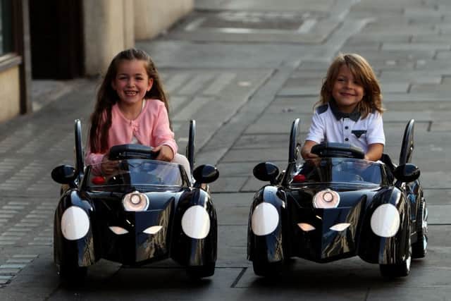 Four-year-olds Emee (left) and Teddy play with the Batman 6v Battery Powered Batmobile as Hamleys launches its Christmas toy range.