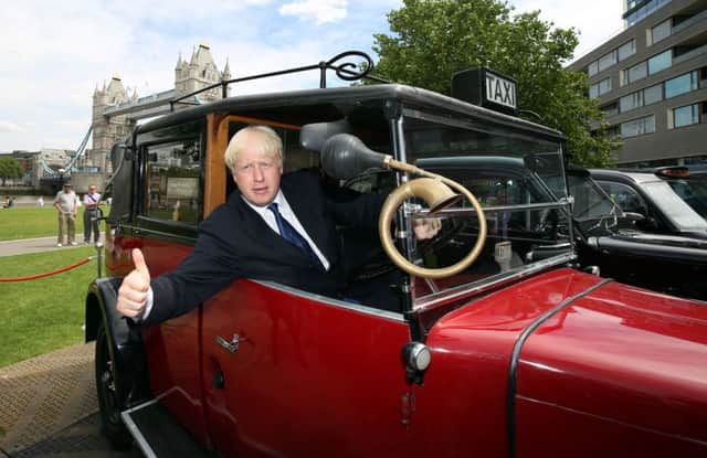 Mayor of London Boris Johnson sits behind the wheel of a vintage taxi outside City Hall in London.
