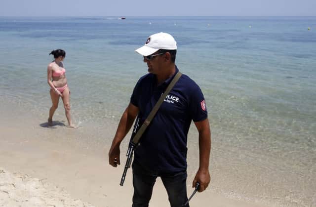 A Tunisian police officer guards the beach area in front of the attacked Imperial Marhaba Hotel in Sousse, Tunisia.