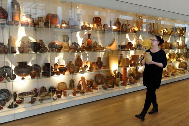 Fiona Green, collection facilitator, in the new York Art Gallery, walking past the 'Wall of Pots'