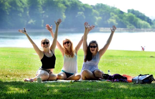 Niamh Hendron, Emily Stocks, and Abby Wheeler, all 17, enjoying the warm weather in Roundhay Park, Leeds.