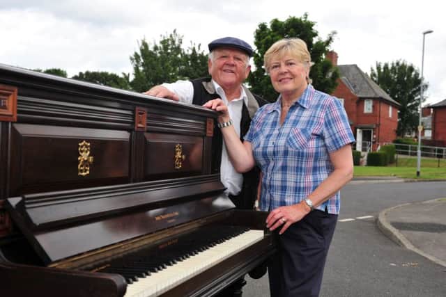 Graham Tempest and his sister Margaret Audsley push an upright piano through the streets of Gipton, as they did in the 19050s. Picture by Tony Johnson